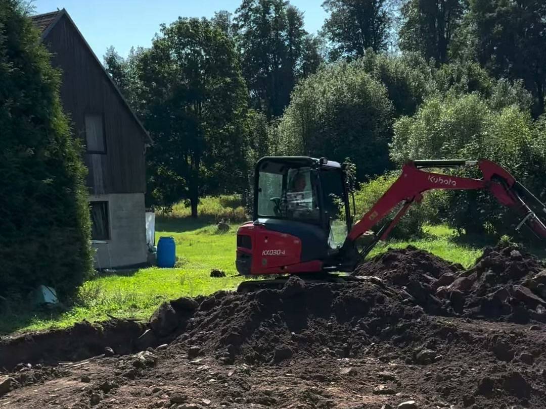 Bagr při terénních úpravách před pokládkou dlažby